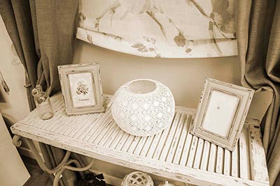 Cortinas Regalos y Decoración Interior 01 Mesa pequeña de madera con dos marcos de fotos y un portavelas