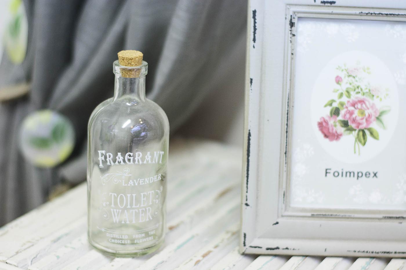 Regalos - La Rosa d'Alexandria Botella transparente y portafotos vintage blanco sobre madera blanca