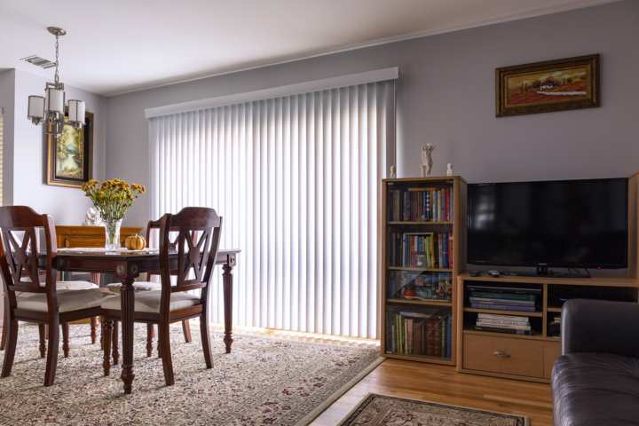 Cortines La Rosa d'Alexandria - Instal•lació a domicili Cortines verticals Cortines verticals en finestra de saló clàssic d'habitatge Instal·lació de cortines de la Rosa d'Alexandria