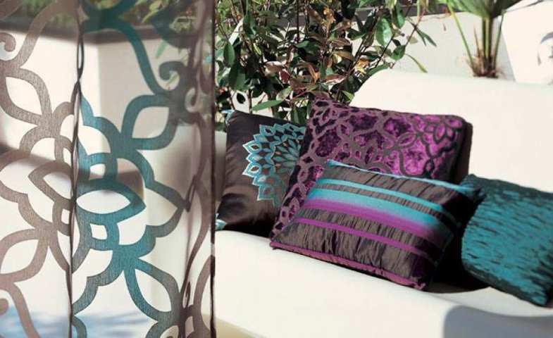 Cortines Visillos _ La Rosa d'Alexandría Barcelona i Mataró Cortines Visillostransparents amb estampats de color marró i turquesa de fons sofà blanc amb coixins foscos