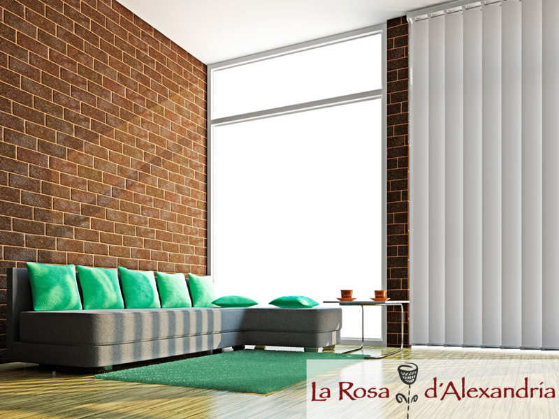 salón moderno ventanal con cortinas verticales pared de ladrillo, sofá, moqueta y suelo de madera